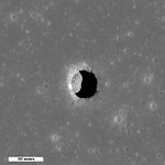 En vy uppifrån av Mare Tranquillitatis där soluppgången visar en månkrater med klippblock på en annars slät månyta. Bilden visar ett område på 400 meters bredd med norr uppåt på bilden.