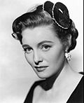A black-and-white picture of Patricia Neal in a striped collared shirt