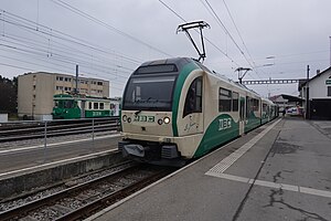 Green and white train next to station platform