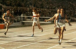 Four sprinters, seen head-on at the tape