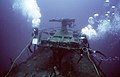 U.S. Navy divers measuring the deck gun in 1987 as part of Project Sea Mark for Navy historic sites