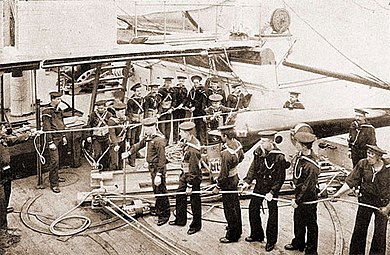 Gunners operating a pivot gun aboard a United States Navy vessel in the late 19th century