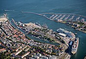 il porto-canale dall'alto ove si distinguono il vecchio corso (Alter Strom) e il nuovo corso del canale marittimo (Neur Strom/Seekanal); ormeggiate in banchina invece, dall’alto verso il basso: fregata tedesca Mecklenburg-Vorpommern (F218), nave scuola Amerigo Vespucci, le navi da crociera AIDAmar (innanzi alla stazione marittima) ed MSC Poesia