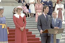 Charles giving a speech at a podium, with Diana standing to his right