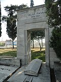 Squared stone arch reading "Talat Pasa 1874-1921" over a stone sarcophagus
