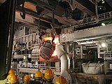 A ladle pouring molten steel into a Basic Oxygen Furnace for secondary steelmaking, inside a steel mill factory in Germany