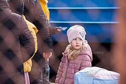 Girl in pink coat and pink hat with train in the background
