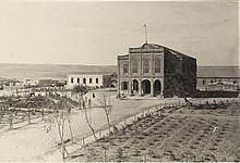 Large building, with wide road and field in front