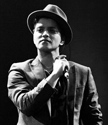 A black and white photograph of Bruno Mars holding a microphone.