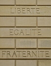 Devise française « liberté, égalité, fraternité » gravée sur un mur.