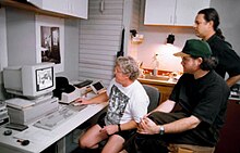 Jack Duganne y Holbert trabajan en una imagen usando Photoshop en una computadora Apple Macintosh con el fotógrafo George Holz en un estudio. Imagen cedida por Nash Editions.