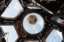 Photographie du ballon en apesanteur, la Terre en arrière-plan.