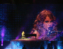 Taylor Swift singing on piano, on the Fearless Tour