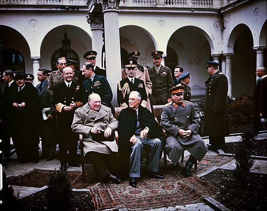 From left to right: Winston Churchill, Franklin D. Roosevelt, and Joseph Stalin. Also present are British Foreign Minister Anthony Eden and Soviet Foreign Minister Vyacheslav Molotov (far left); Field Marshal Sir Alan Brooke, Admiral of the Fleet Sir Andrew Cunningham, RN, Marshal of the RAF Sir Charles Portal, RAF, (standing behind Churchill); General George C. Marshall, Chief of Staff of the United States Army, and Fleet Admiral William D. Leahy, USN (standing behind Roosevelt).