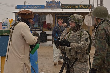 A U.S. Soldier, second from right, with the 3rd Squadron, 2nd Cavalry Regiment interacts with a civilian role player during a mission rehearsal exercise at the Joint Multinational Readiness Center in Hohenfels
