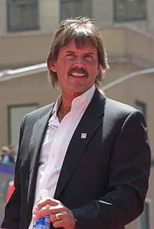 A man in a black suit jacket and white shirt