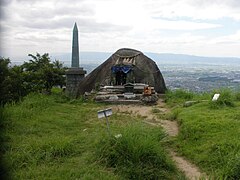 山頂の基肄城跡 中央は霊霊石(「たまたまいし」と呼ぶ)、左後方に天智天皇欽仰之碑