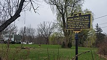 a picture of the marker with the house behind it