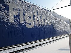 Station sign covered by ice