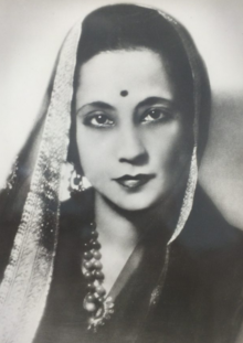 A fair-skinned Bengali woman wearing a dupatta to loosely cover her head, and dark beads