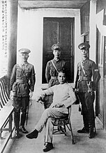 黄埔軍官学校入学式後の国民党要人の記念撮影。 中央の椅子に腰掛ける人物が孫文、その後に蔣介石。蔣と並ぶのは教官の何応欽（左）と王柏齢（右）。