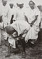 Gandhi picking salt during the same protest, which was a criminal, yet nonviolent, act of civil disobedience.