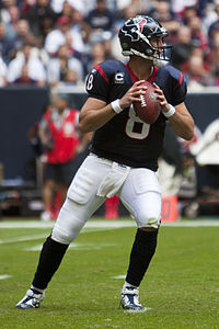 A football player in a blue and red uniform running on a football field