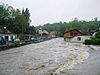 A large amount of water rushes down a city street, threatening to flood several houses