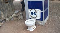 Vaso sanitário e cabina telefônica exposta para efeito de humor no jardim