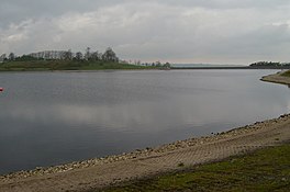 A lake with tree on the far bank