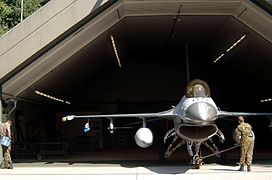 A General Dynamics F-16 Fighting Falcon in front of a Hardened Aircraft Shelter, a special type of hangar