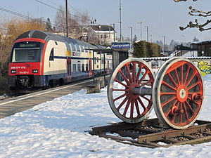 White double-decker train next to side platform