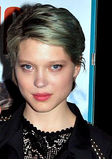 Photographie au format portrait et en couleurs d'une jeune femme aux cheveux coupés courts et teints en bleu