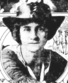 A black and white photograph of a woman in a boater-style hat