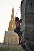 Un grimpeur sur un bâtiment vue en contre-jour