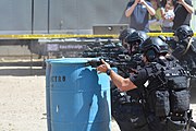 LAPD SWAT Officers firing HK416 assault rifles fitted with the DBAL-A2 variant of the PEQ-15, on the top of the hand guard.