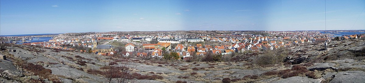 Bild tagen norrut över Kungshamn. Längst till vänster ser man Hasselösund och Smögenbron, till vänster om kyrkan ligger Gravarne och Sandbogen. Längst bort i mitten ligger Bäckevik, strax höger om det ligger Väggabacken. På udden näst längst till höger ligger Valberget och allra längst till höger syns en del av Fisketången. Vid horisonten till höger skymtar Preemraff Lysekils skorstenar.