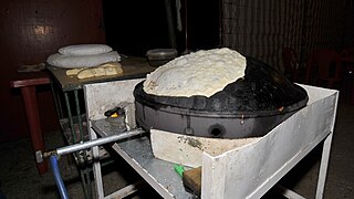 Markouk being baked on a convex saj