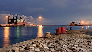 Sur la gauche le navire Odeep One, au fond à droite le phare du môle Saint-Louis. Vue depuis l'extrémité sud du quai de la République à Sète, France. Novembre 2020.