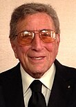 Profile picture of elderly White man smiling at the camera and wearing sunglasses
