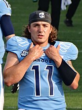 Football player gripping his shoulder pads