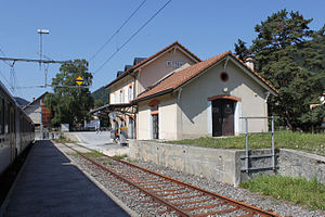 Two-story station building next to a railway line