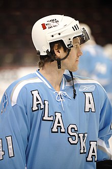 Hockey player standing on the ice, looking to the right