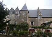 Vue de la façade d'un bâtiment comportant tour extérieure d'escalier et mansardes sur une partie des combles.