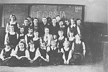 Boys and girls in school uniform, with a teacher