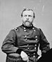 Head and torso portrait of a white man with a full beard, wearing a military jacket.