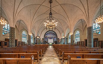 Vista interior da igreja de São Paulo em Lucerna, Suíça. É uma igreja católica romana na periferia sul da cidade. É uma das duas maiores igrejas da cidade e um Bem Cultural de Importância Nacional. O desejo de uma nova igreja surgiu no início do século XX. Após 250 anos, a igreja de São Paulo foi a primeira igreja católica a ser reconstruída em Lucerna. A pedra fundamental foi lançada em 22 de maio de 1910. Sua consagração ocorreu em 15 de agosto de 1912. Foi construída segundo os planos do arquiteto de Zurique Karl Moser, considerado um pioneiro do modernismo. A Art nouveau prevalece no interior do templo. As paredes e pilares são pintados com ornamentos verdes, azuis e dourados, motivos de árvores e plantas. (definição 7 431 × 4 644)