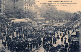 La foule attendant la sortie des corps des victimes devant la bouche de la station Couronnes. Cliché pris au carrefour de la rue des Couronnes et du boulevard de Belleville.
