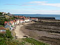 West Shore, Pittenweem from the West Braes showing skerries in the foreground, the old harbour in the mid-ground and the new harbour in the background. The Isle of May (or May Island) is on the horizon.