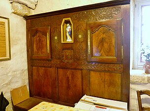 Maison du marquisat : intérieur traditionnel d'une maison du Cap Sizun, panneau mural en bois avec une niche contenant une statue de la Vierge Marie.